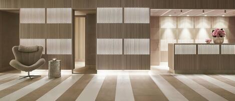 A modern reception area with a reception desk, a seating area with a chair, and a decorative vase.