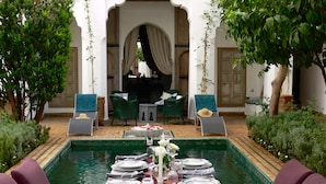 A dining area with a pool table, chairs, and a table set for a meal. - Riad El Mezouar (Marrakech)