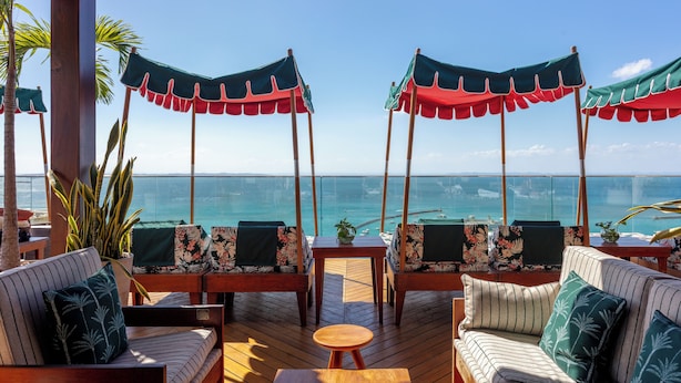 A deck with seating and umbrellas overlooking the ocean. - Fera Palace Hotel (Salvador)