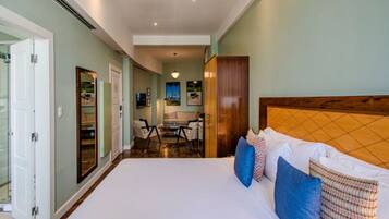 Un dormitorio amplio con una cama grande, cabecera de madera y vista al comedor.
