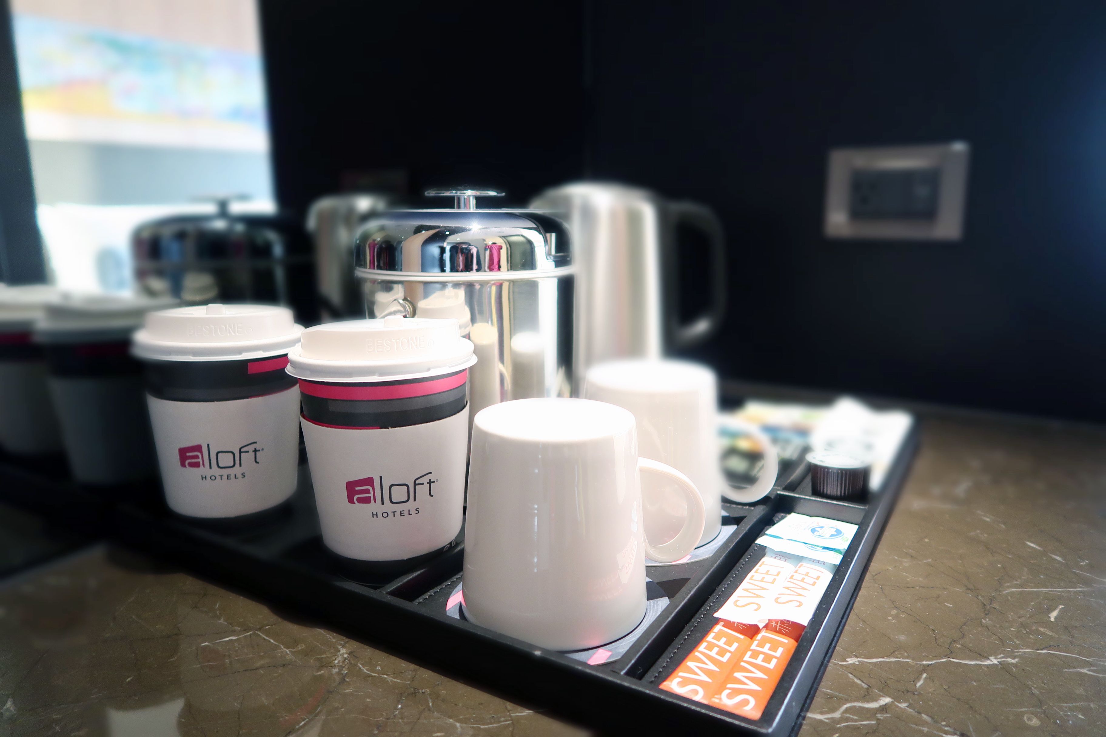 A coffee station with branded coffee cups and a coffee machine.