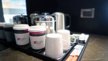 A coffee station with branded coffee cups and a coffee machine.