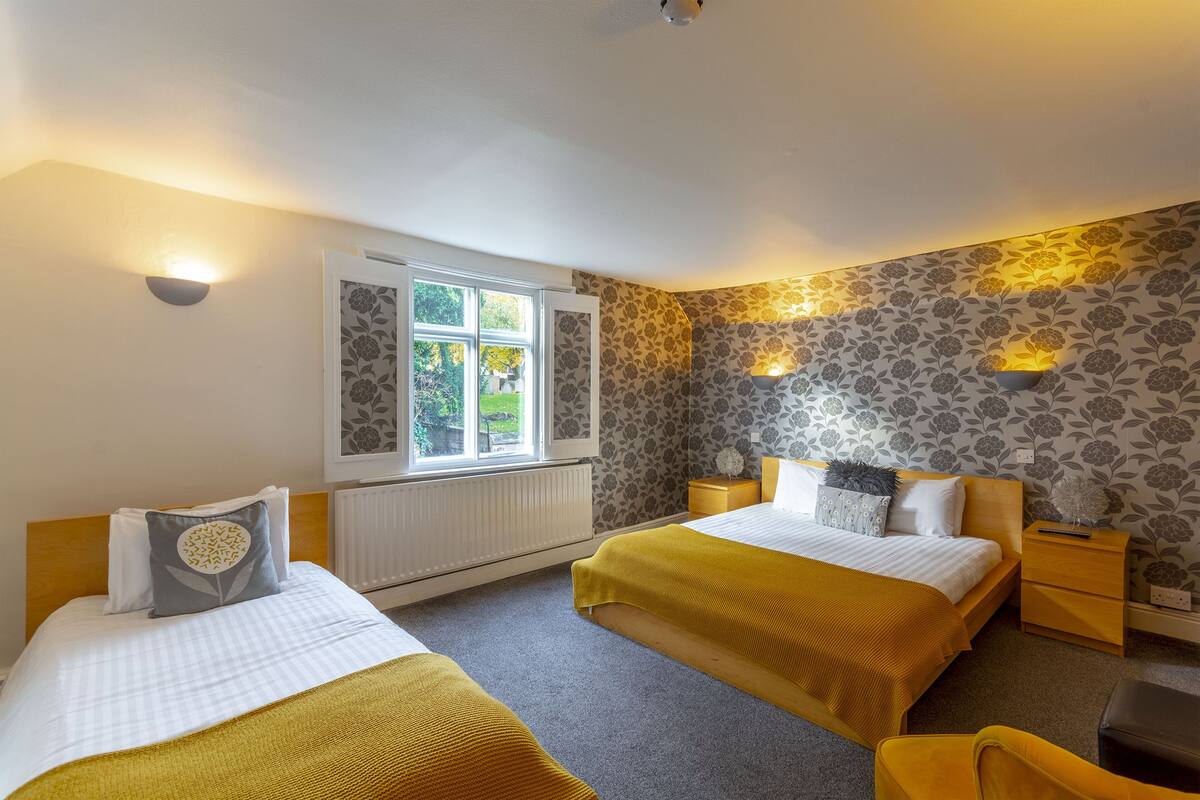 A double room with two beds, a window, and a radiator.