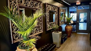 A hallway with ornate mirrors, potted plants, and a bench. - Hotel Kilbourne Downtown Sandusky (Sandusky)
