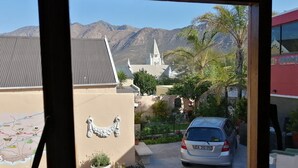 A view of a parking area with a car, a map on the wall, and a church in the background.
