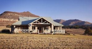A single-story house with a gabled roof, a front porch, and a fenced yard.