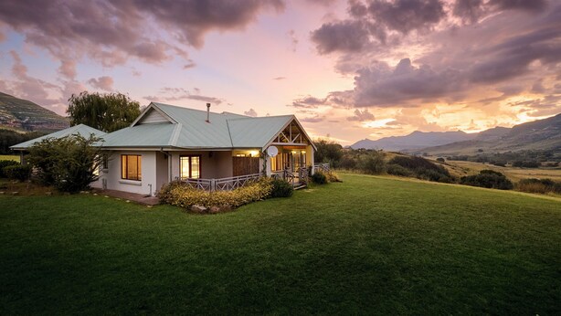 A house with a sloped roof, a porch, and a well-maintained lawn. - Dynasty Red Mountain Ranch (Clarens)