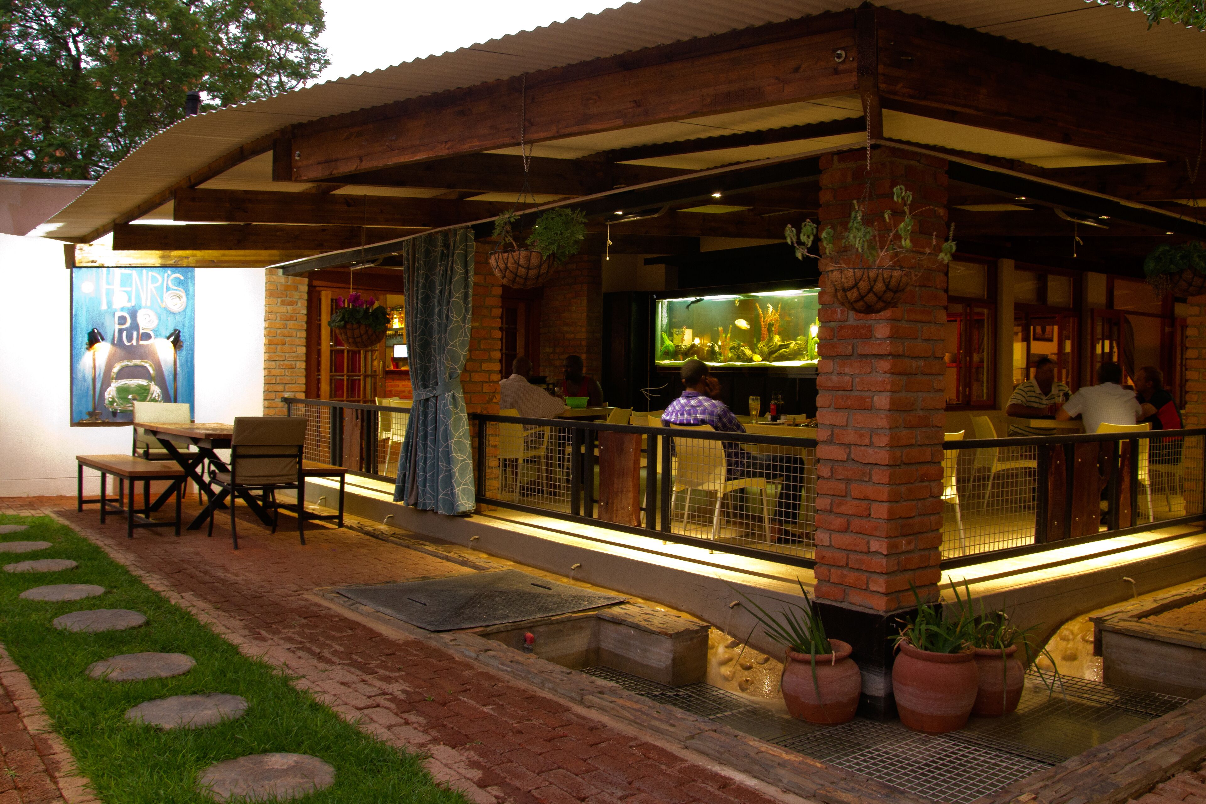 Un restaurant doté d’une terrasse, d’une façade en briques et d’un grand aquarium.
