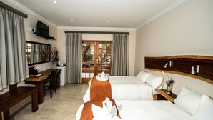 A hotel room with two beds, a desk, a TV, and a view of the outdoors. - Casa Forno Country Hotel (Otjiwarongo)