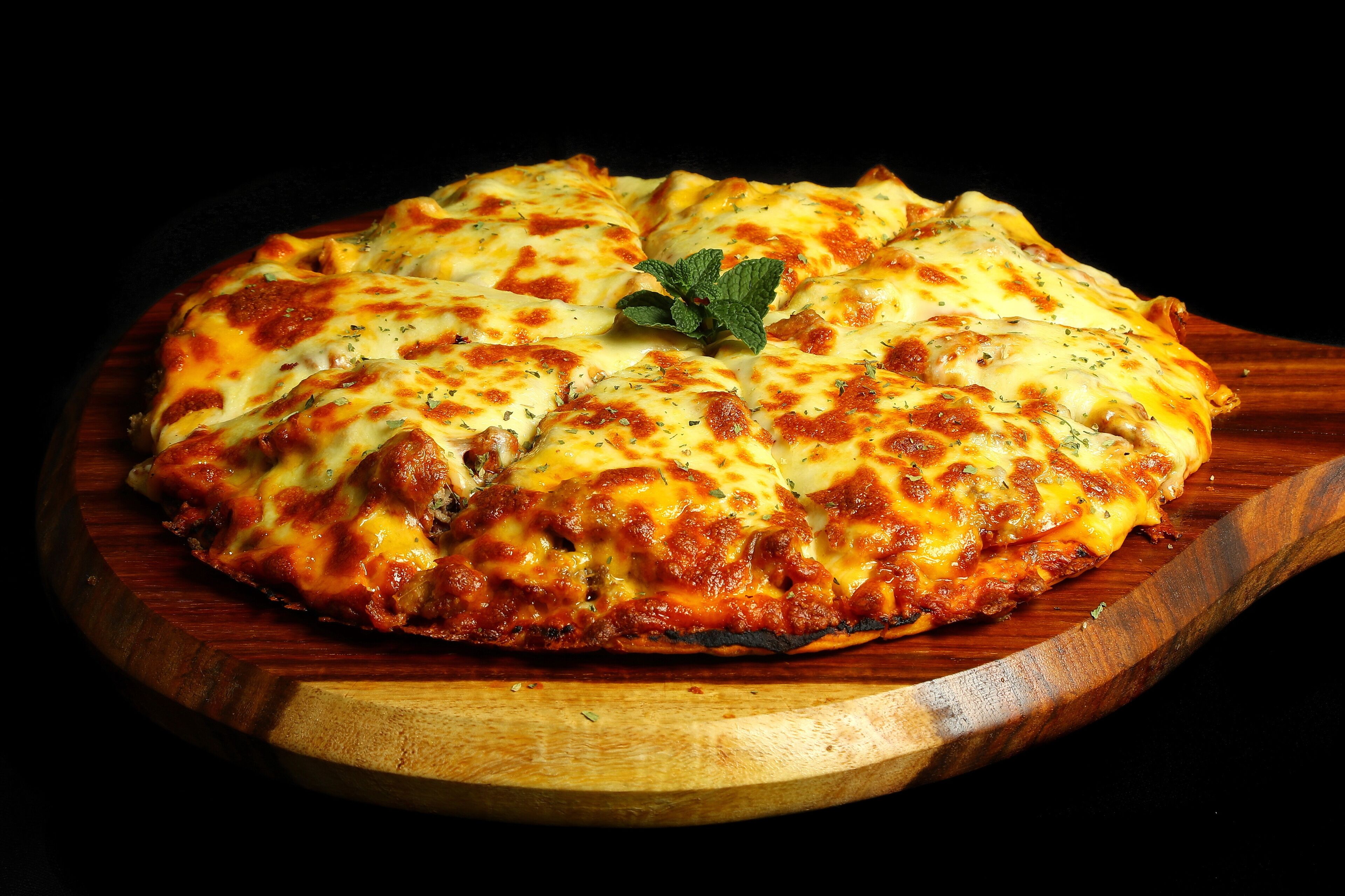 Eine Pizza auf einem Holzbrett.