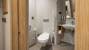 Un baño moderno con inodoro, lavabo y ducha.