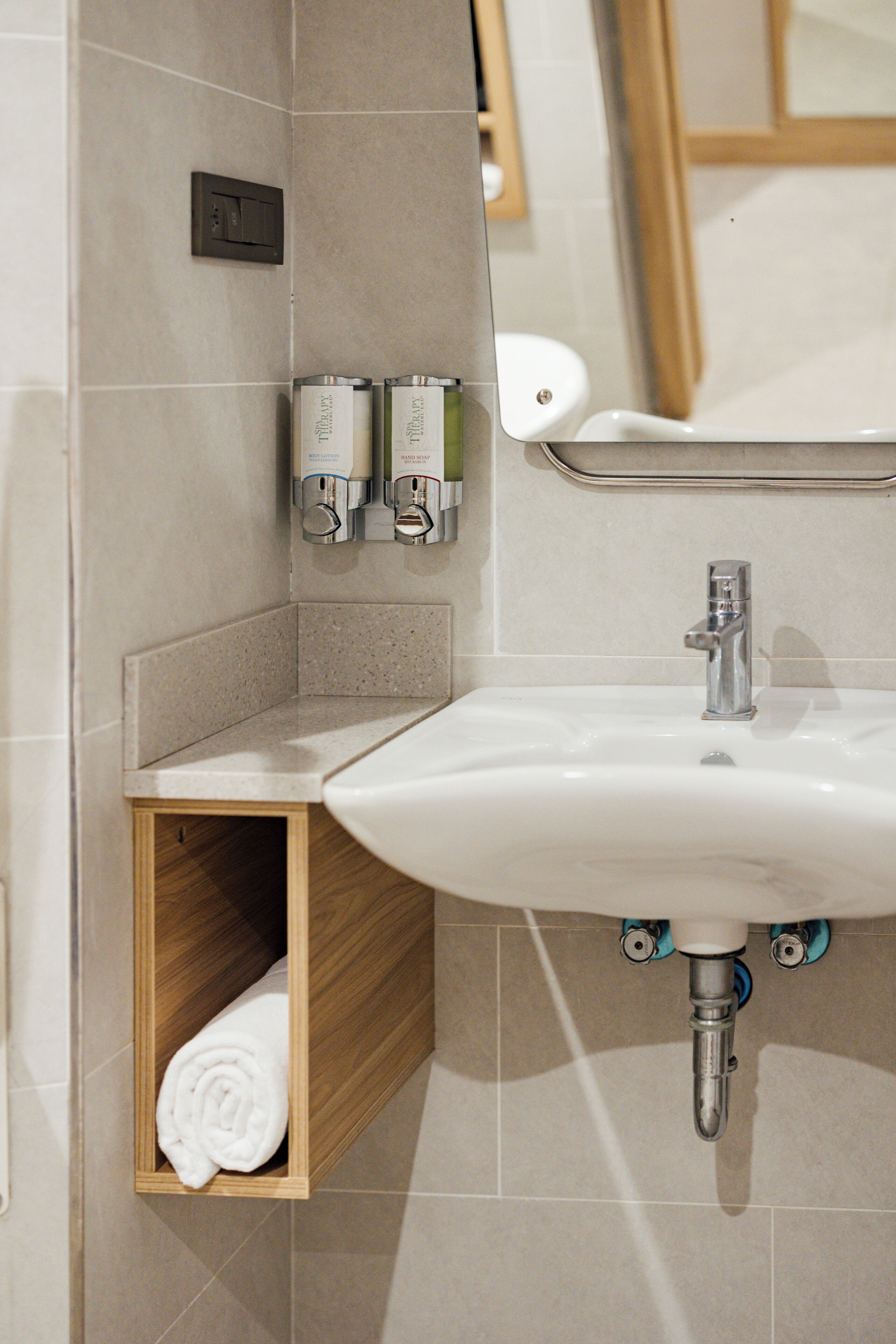 A bathroom with a sink, towel storage, and toiletries.