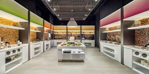 A modern buffet setup with multiple serving stations, each with a variety of food items and utensils.
