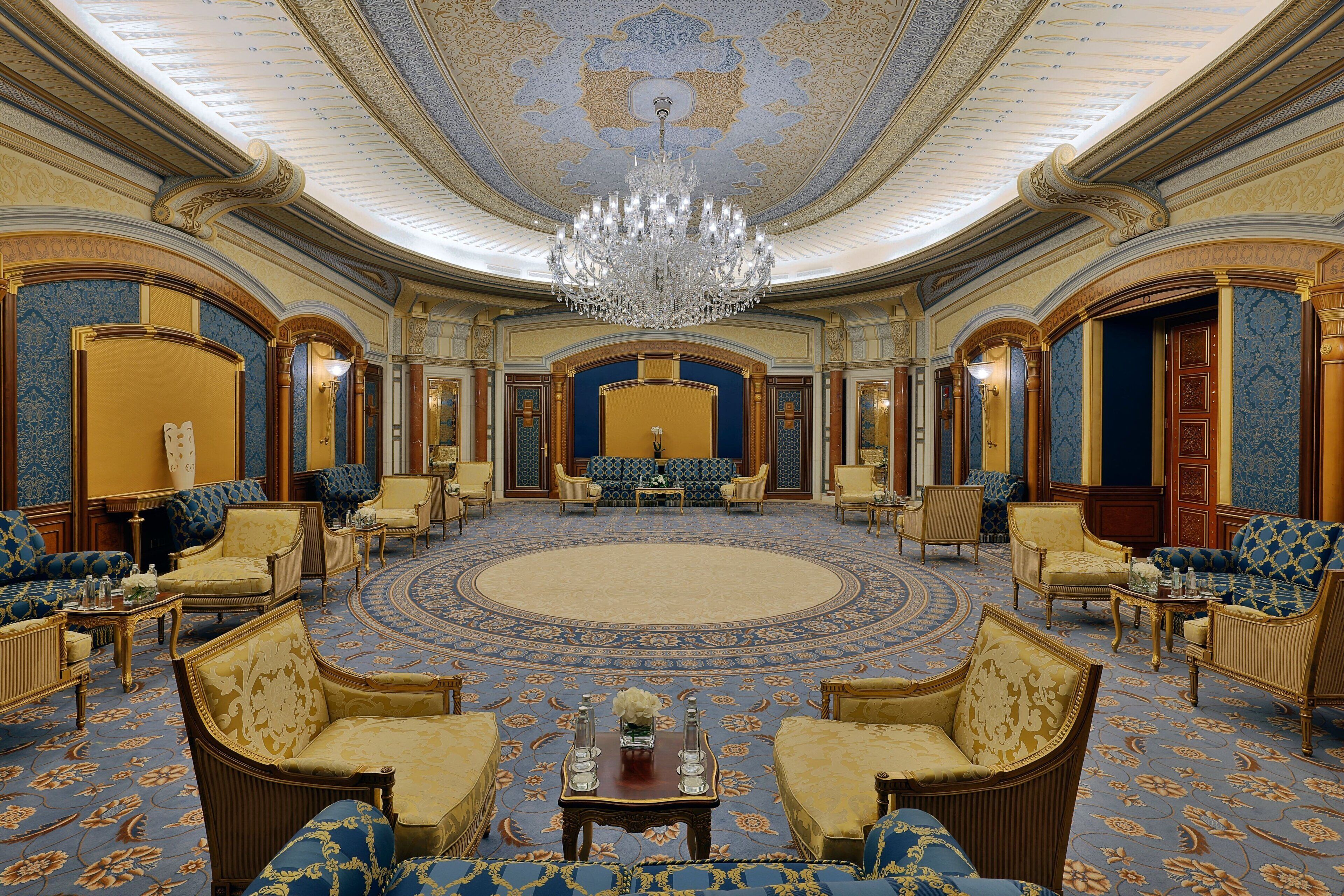 Un vestíbulo imponente con candelabros decorativos, asientos cómodos y una alfombra estampada.