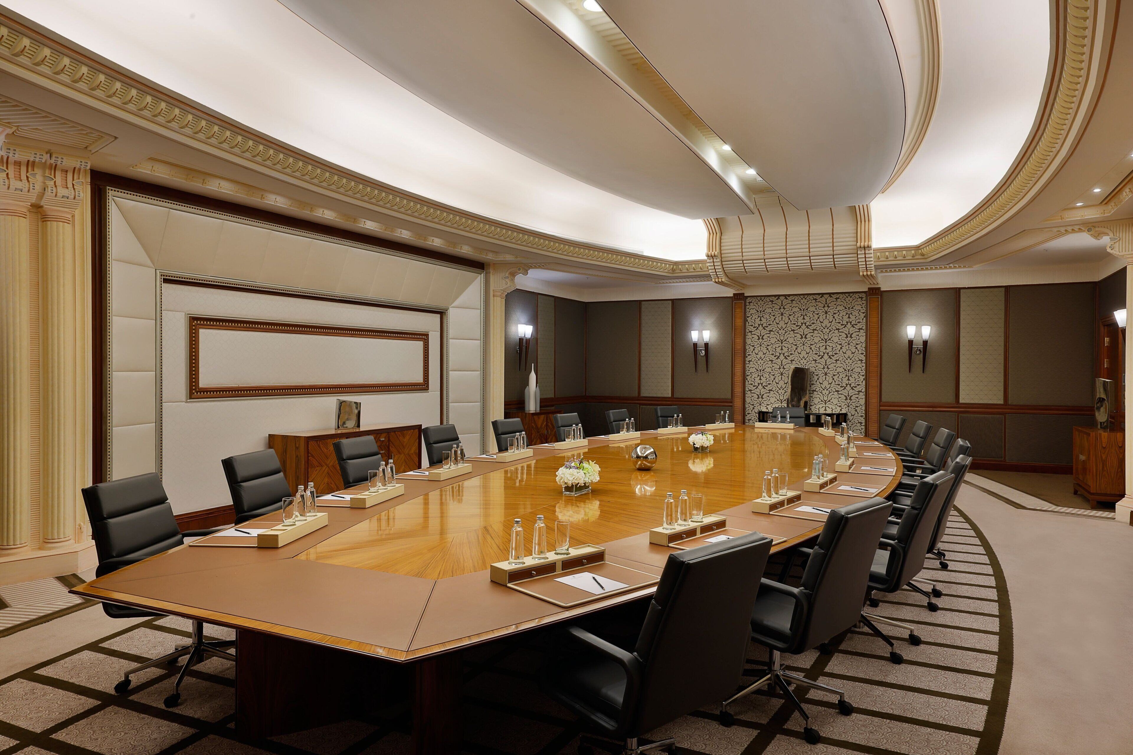 A large conference room with a long table, multiple chairs, and a speaker system.