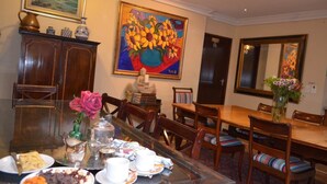 Un comedor con una mesa de madera dispuesta para una comida, rodeada de sillas.