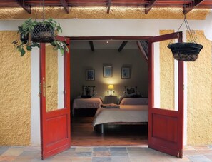A doorway leading into a room with two beds, a hanging plant, and a lamp. - Steytlerville Villa Guest House (Steytlerville)
