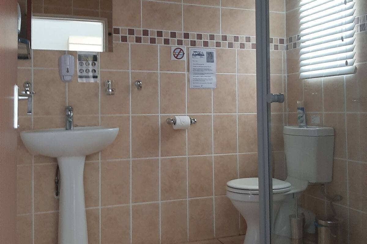 A bathroom with a sink, toilet, and shower.