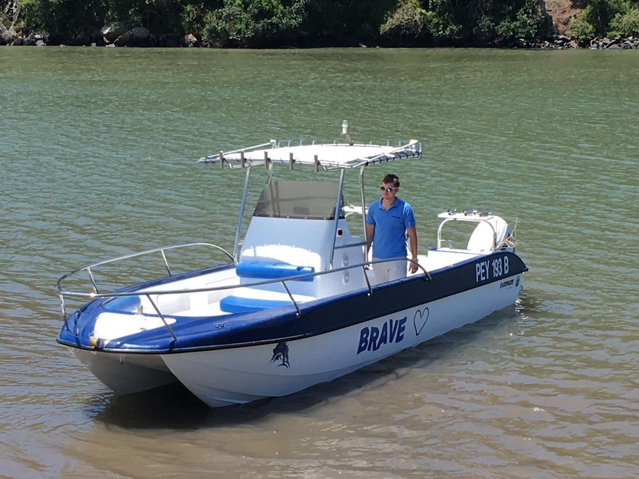 A boat named 'BRAVE' with a person on board, floating on calm water.
