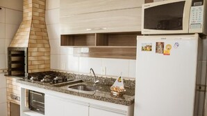 Una cocina equipada con horno empotrado, microondas y refrigerador.
