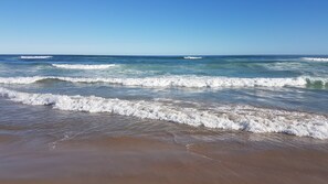 Una playa con olas rompiendo suavemente en la orilla.