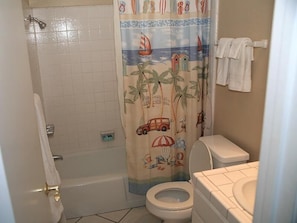 Ein Badezimmer mit Dusche, Toilette und einer Strandmotivananas.
