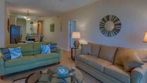 A living room with two sofas, a coffee table, and a ceiling fan. - Sunset Palms (Port St. Joe)