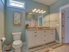 Une salle de bain comprenant des toilettes, un lavabo, un meuble-lavabo et un grand miroir.