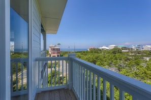 Ein Balkon mit Blick auf Strand und Häuser.