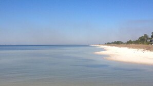 A beach with clear water and a sandy shore.