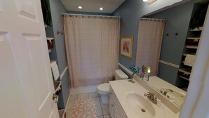Een badkamer met toilet, wastafel en douchegordijn.