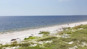 A beach with a sandy shore, a small structure, and the ocean in the background. - Shore to be Fun (Port St. Joe)