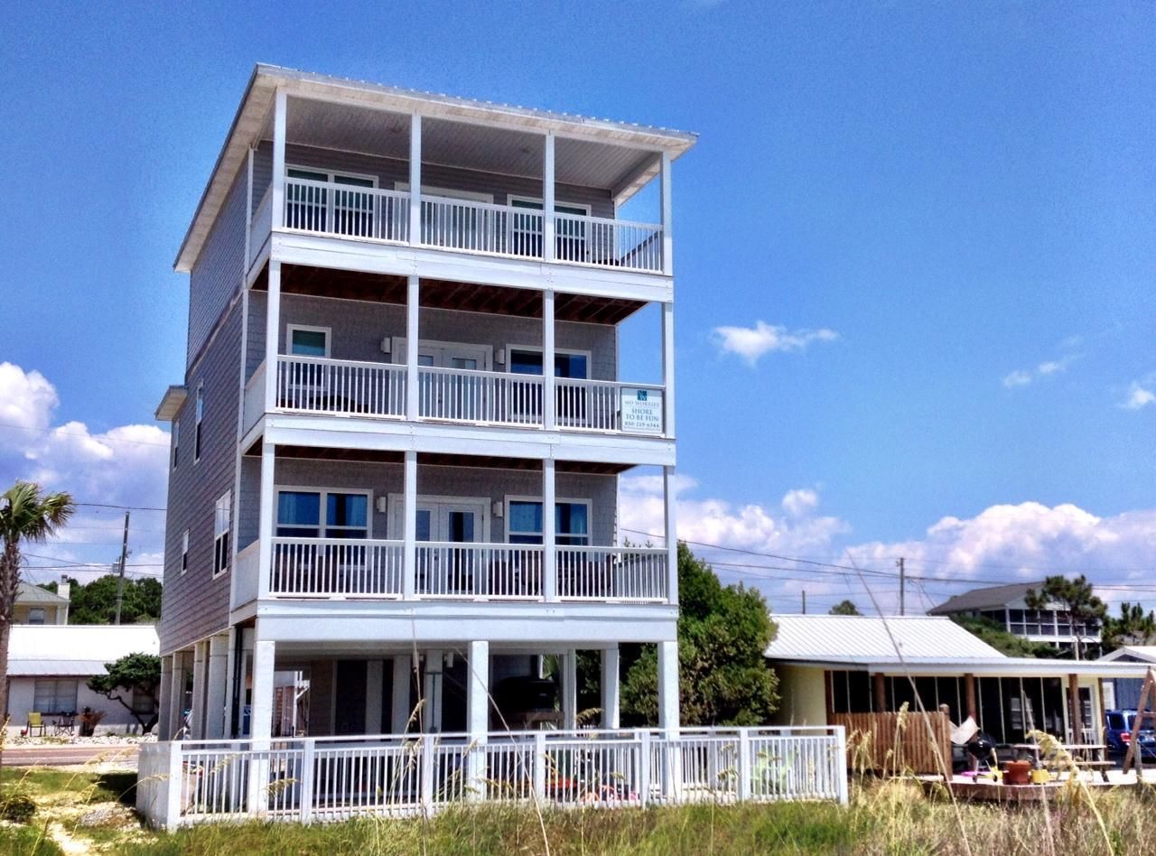 A multi-story building with balconies and a covered front porch.