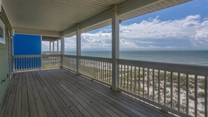 A wooden deck with a railing overlooking a beach and ocean. - Serenity Now (Port St. Joe)