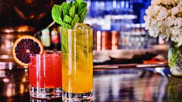 Deux cocktails, chacun agrémenté d’une garniture, sont posés sur le comptoir d’un bar.