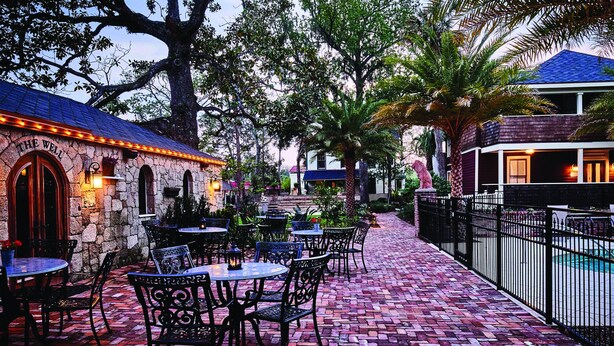 A courtyard with outdoor seating, stone walls, and a pool area.