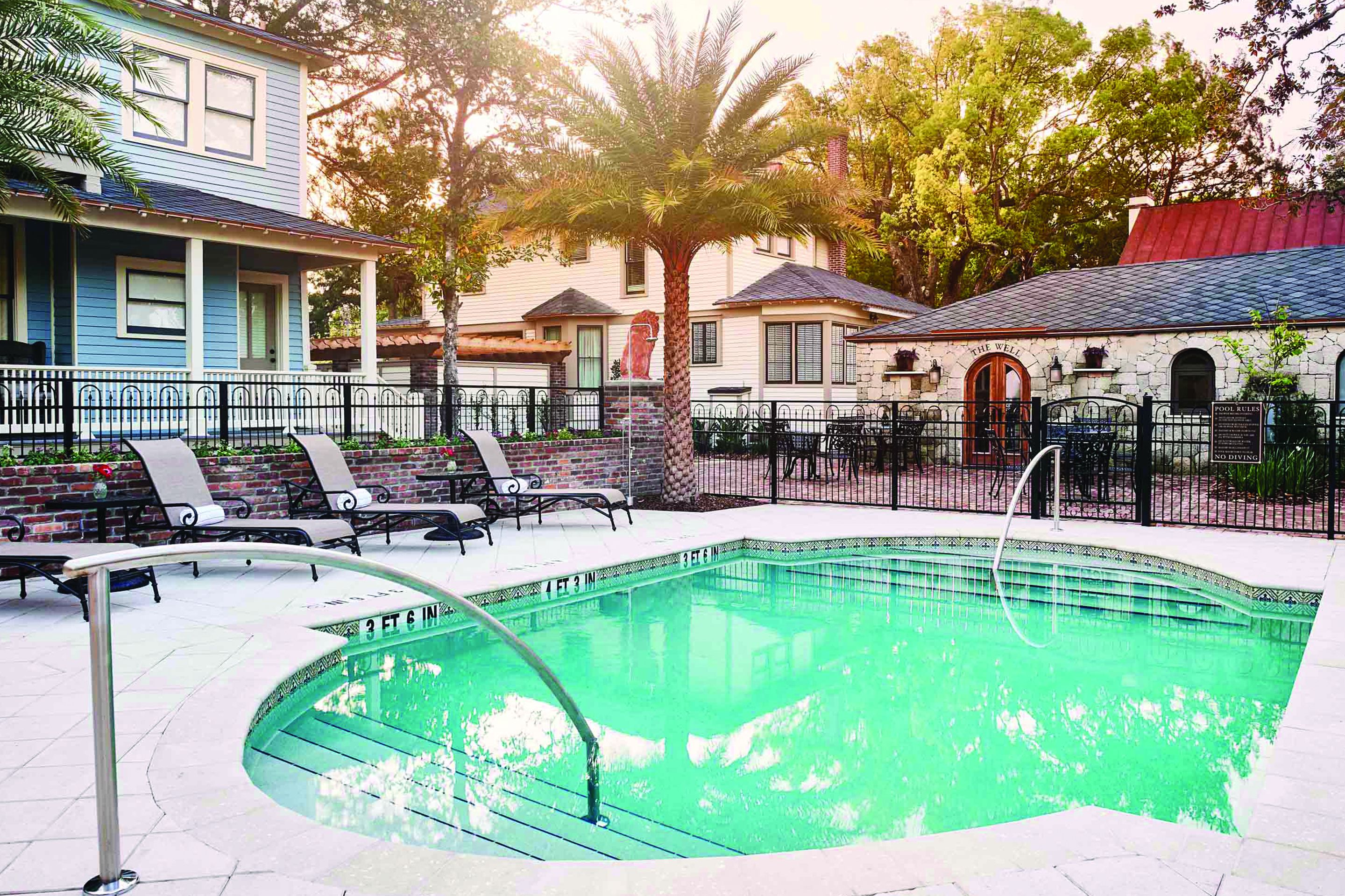 Una piscina al aire libre, sombrillas, sillones reclinables de piscina