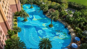 A large, multi-level swimming pool with palm trees and lounge chairs. - Wyndham Hainan Clearwater Bay Resort (Lingshui)