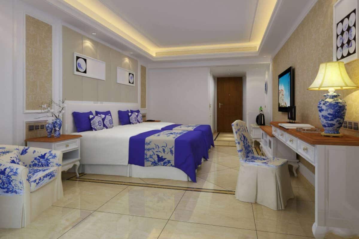 Una habitación de hotel con una cama grande, un escritorio, una silla y un televisor.
