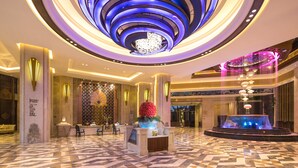 A modern hotel lobby with a central fountain, a reception desk, and a patterned floor. - Wyndham Hainan Clearwater Bay Resort (Lingshui)