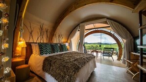 A bedroom with a large bed, a view of the outdoors, and a wooden ceiling. - Parador Cambará do Sul (Cambara do Sul)