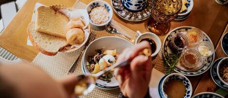 Una mesa de comedor con diversos platos, como pan, un tazón de sopa y una taza de té.