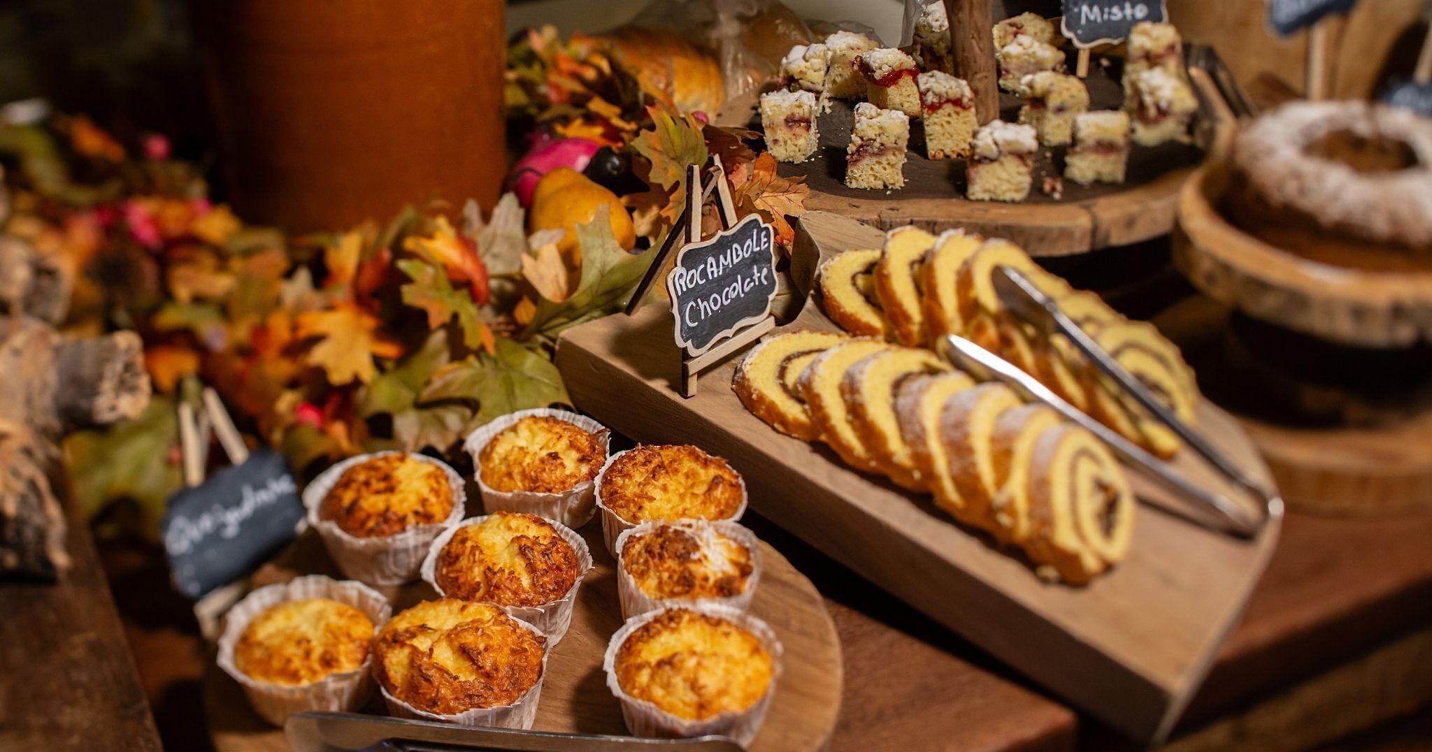 A variety of baked goods displayed on wooden boards, including pastries and cakes.