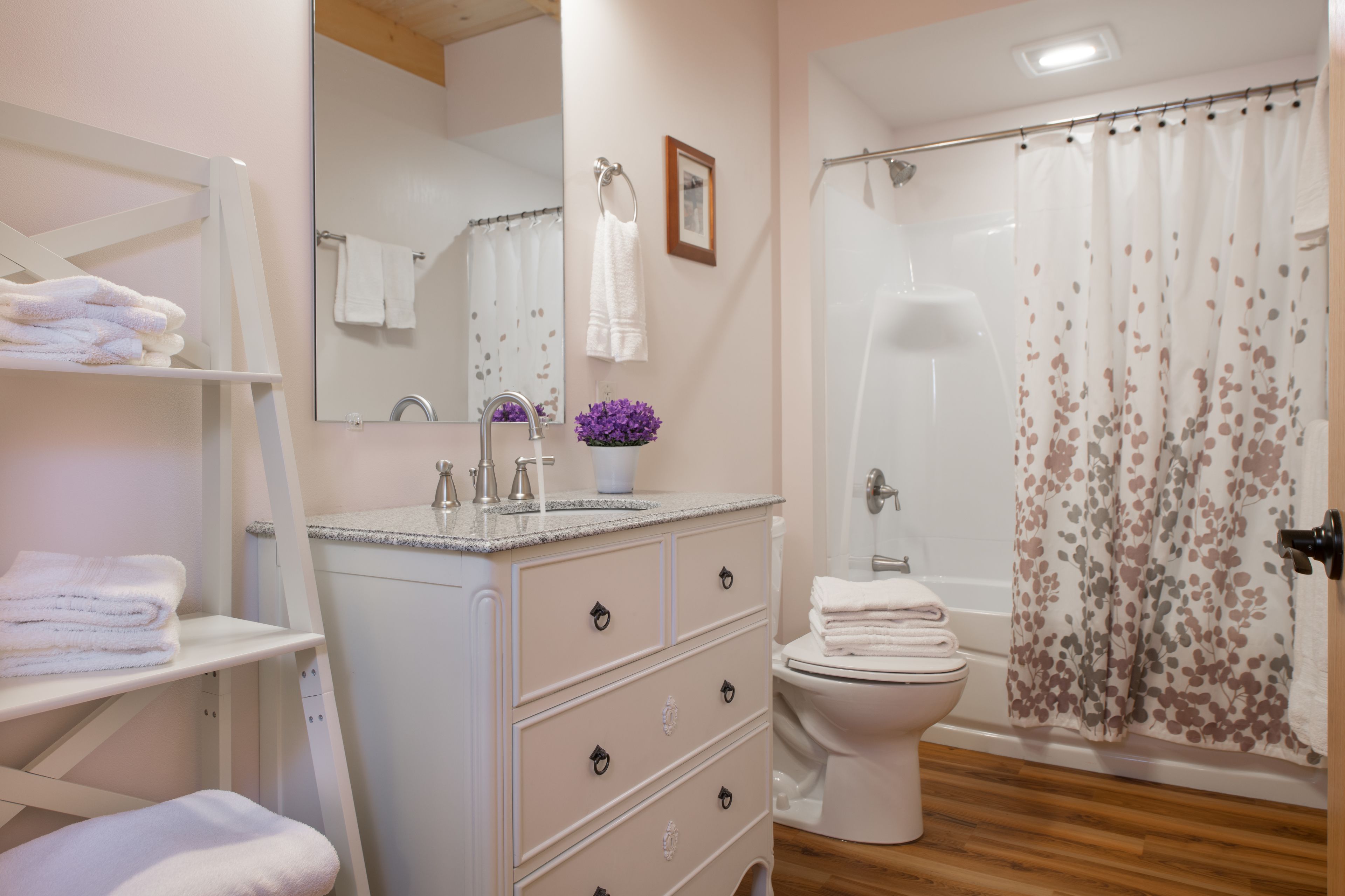 Une salle de bain équipée d’un lavabo, d’un miroir, de toilettes et d’un rideau de douche.