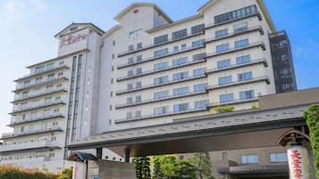 A multi-story hotel with a modern design, featuring a prominent entrance with a covered walkway and signage.