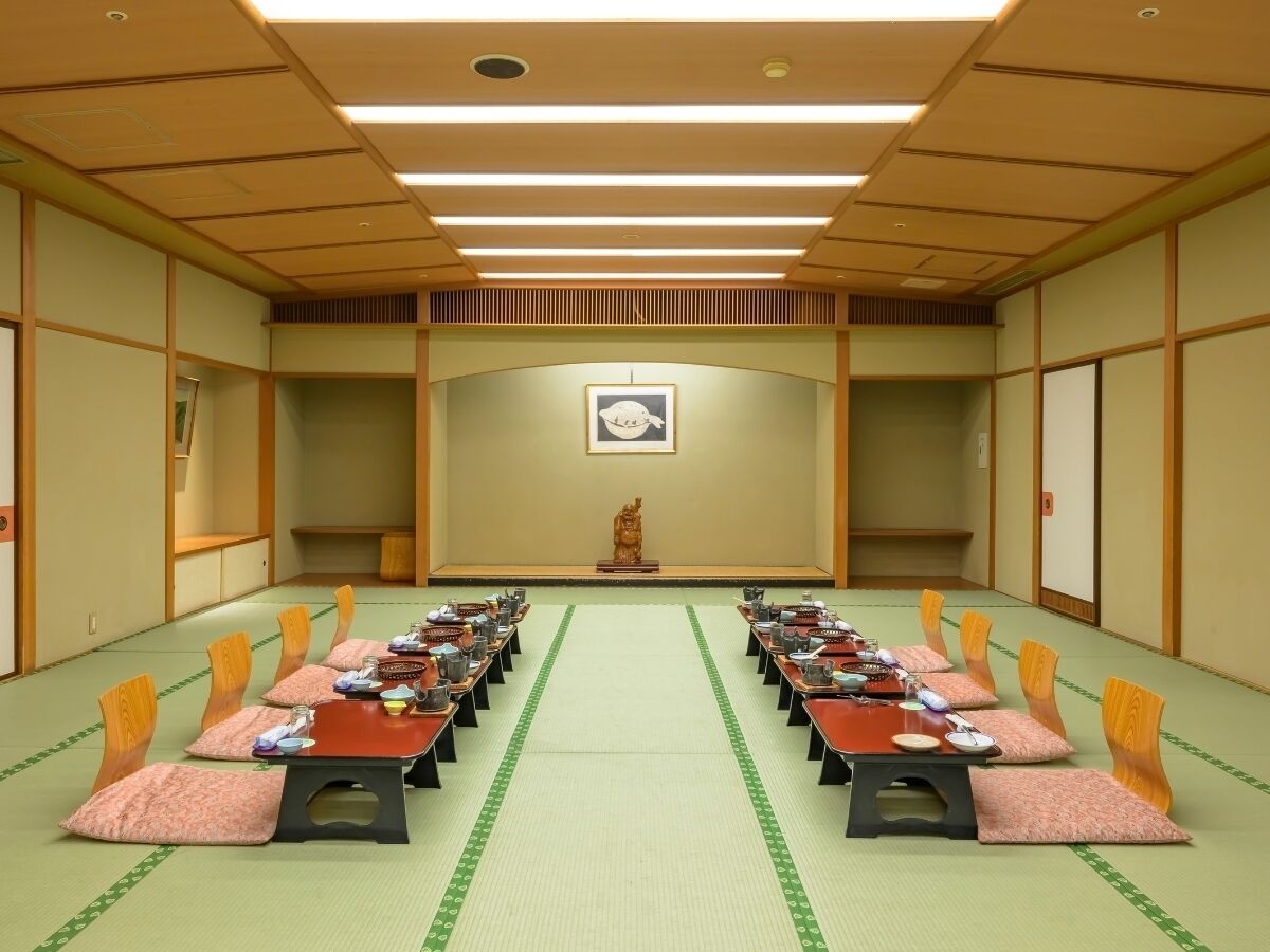 A conference room with a long table, chairs, and a statue in the center.