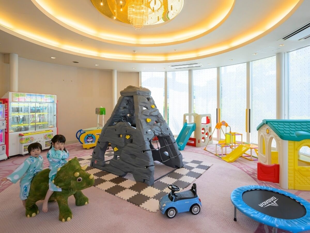 A children's play area with climbing structures, a slide, and a trampoline.