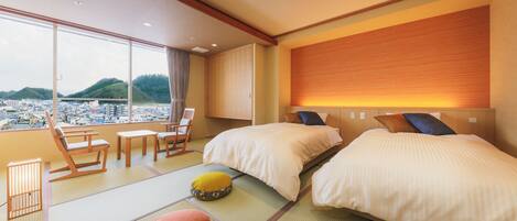 Habitación de hotel con esteras de tatami, dos camas, vista a un paisaje urbano y techo de madera.