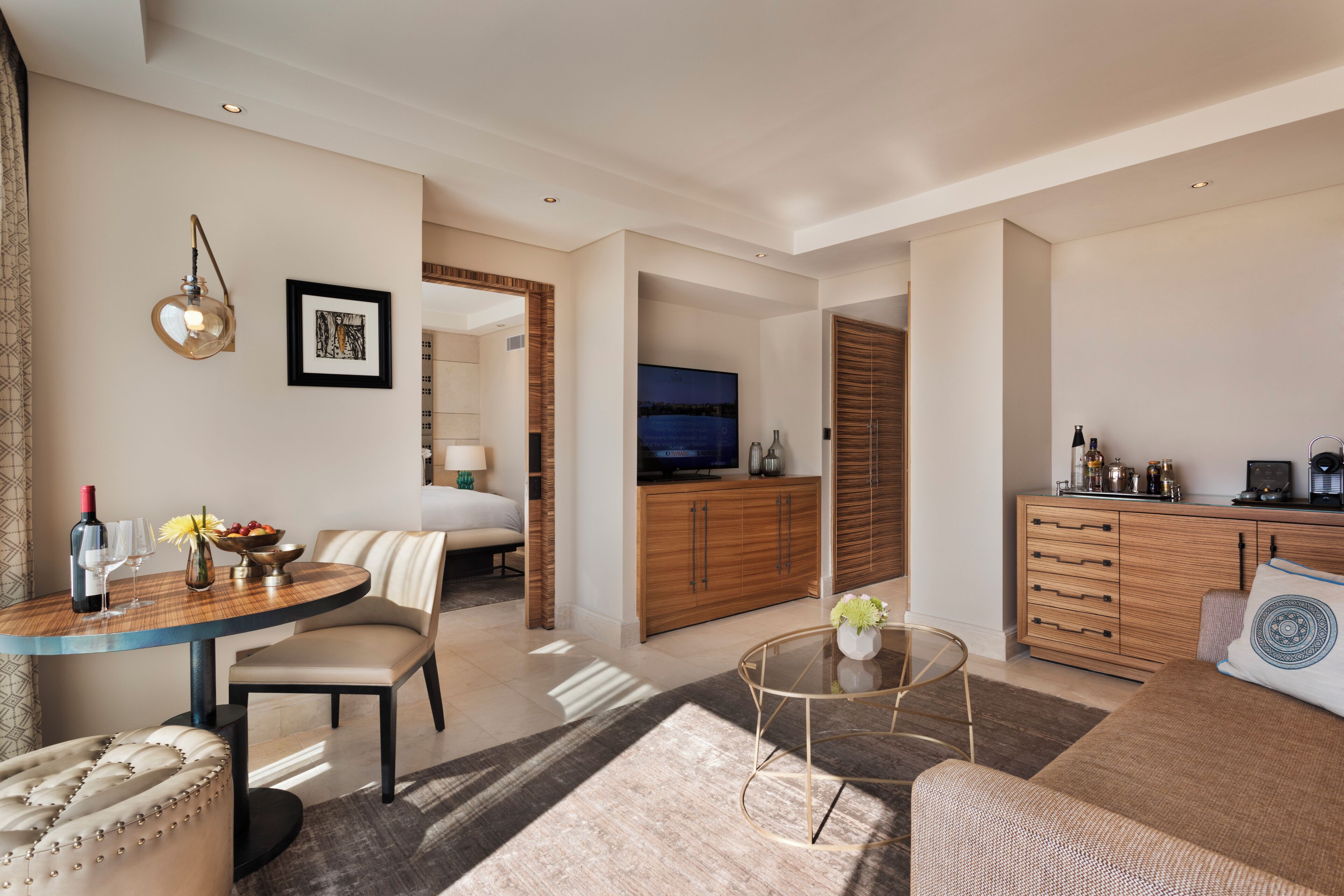 A modern hotel room with a dining area, a living room, and a kitchen.