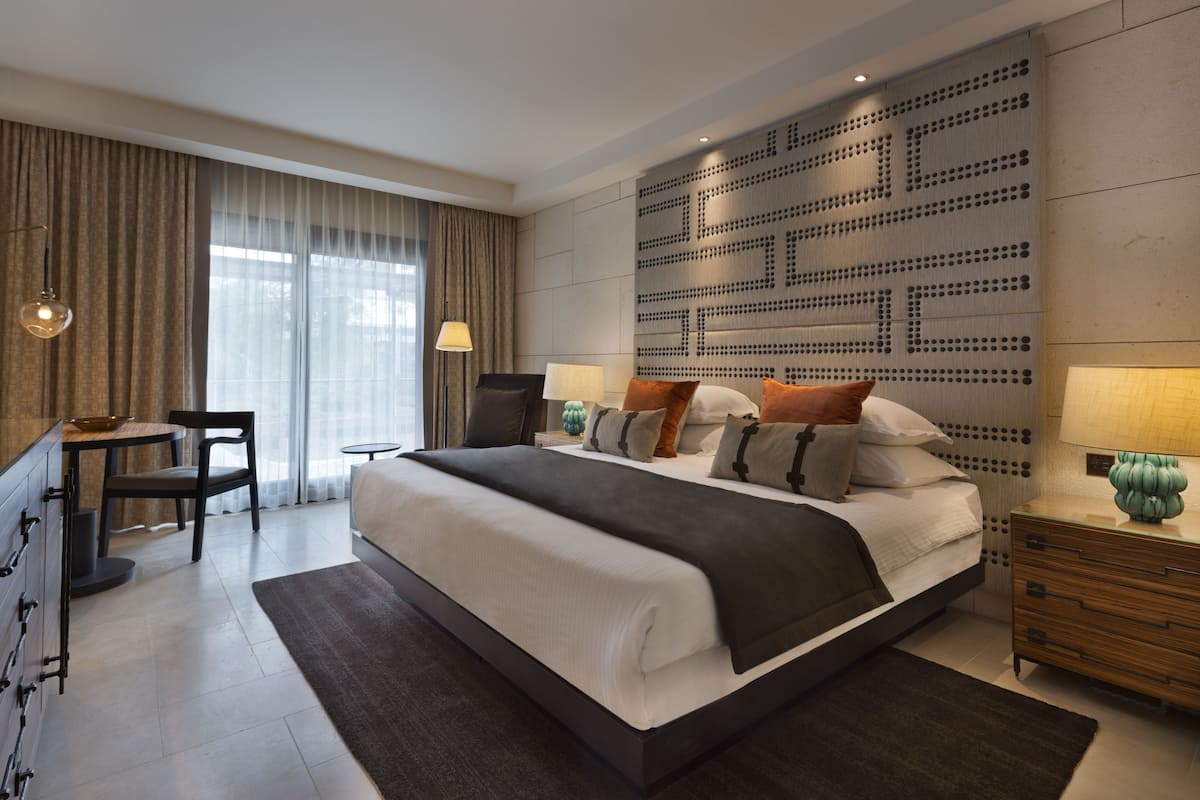 Un dormitorio moderno con una cama grande, un escritorio y una silla.